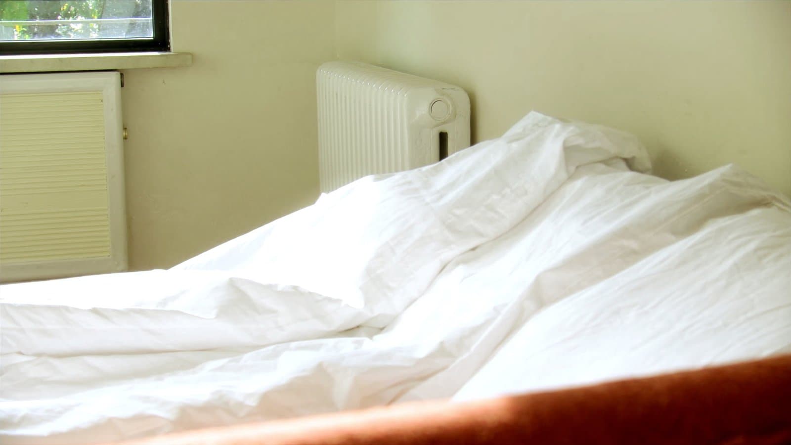 Een lichte slaapkamer met de radiator onder het raam