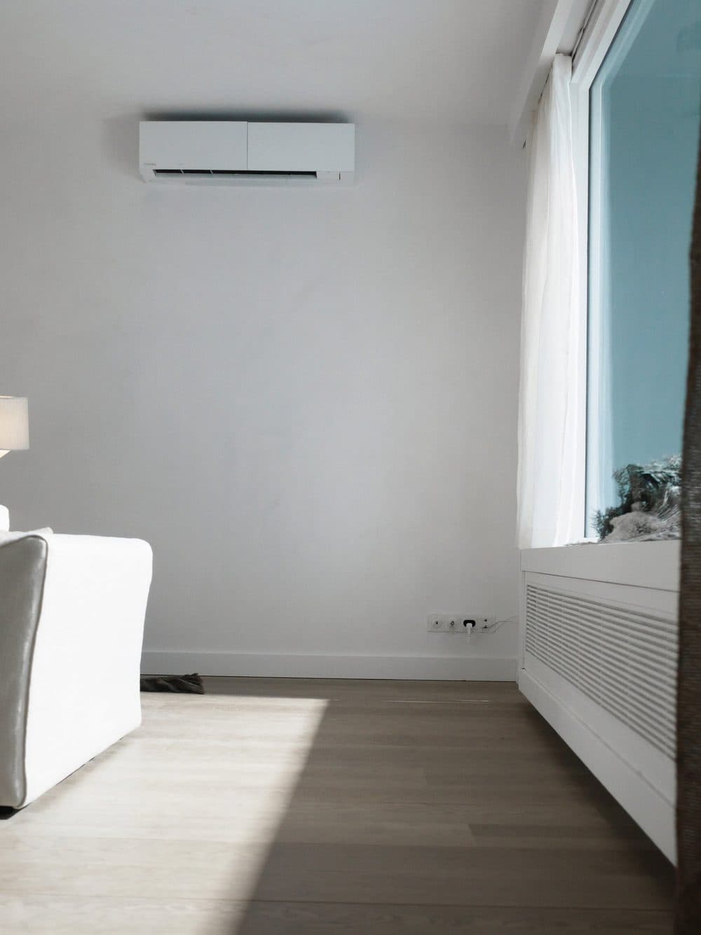 Airco binnenunit hoog tegen de wand in een lichte kamer