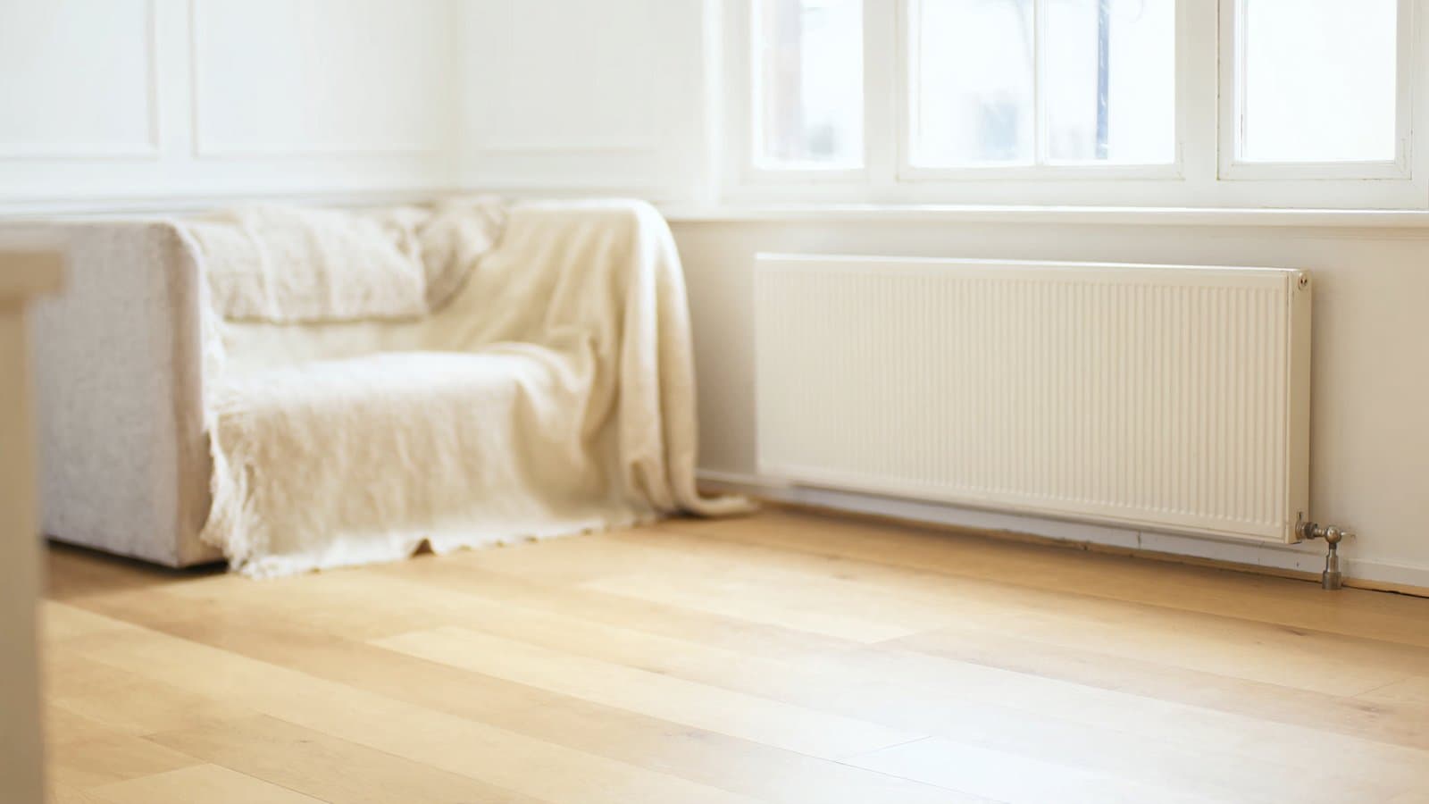 Een lichte woonkamer met de radiator onder het raam